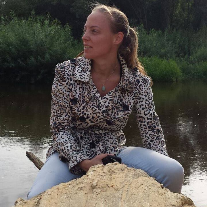 Outdoor portrait of Iris van Rooijen seated beside water